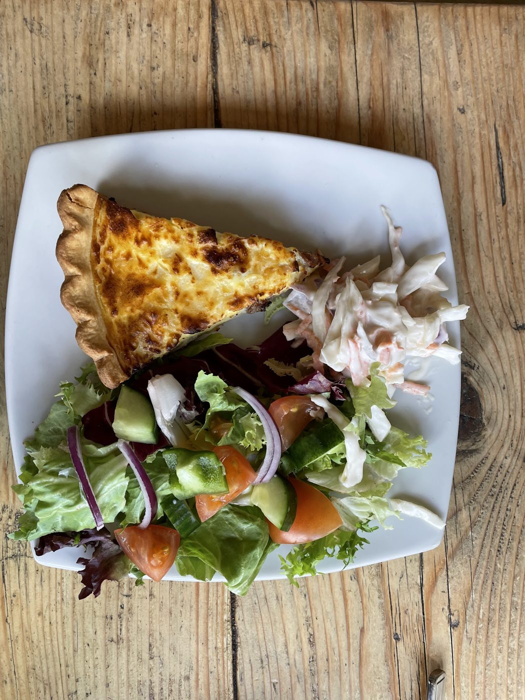 A slice of quiche with salad