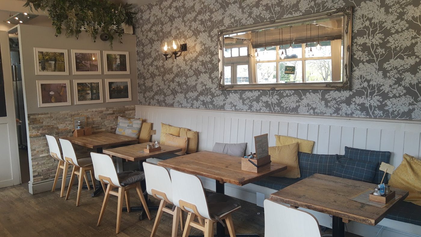 The dining room, with patterned wallpaper and framed pictures